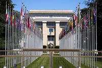 Flagpoles line in rows in front of a building of the United Nations in Geneva, Switzerland