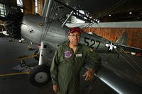 Brian Smith, president and CEO of the Tuskegee Airmen Museum, stands next to a refurbished PT13 at the Coleman A. Young International Airport.