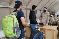 U.S. Army soldiers help Afghan evacuee interpreters through the registration process on a U.S. military base in Kuwait.