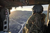 U.S. Army Reserve Spc. Shavaun Brugger, a UH-60 helicopter repairer assigned to Charlie Company, 7th Battalion, 158th Aviation Regiment, peers out of the door of a Black Hawk during Mojave Falcon 2025 at Fort Hunter Liggett, California.