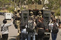Federal agents ride on an armored vehicle in Los Angeles.