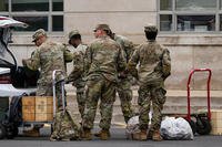 National Guard troops load supplies into a car trunk outside the District of Columbia National Guard Headquarters