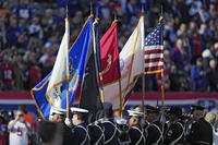Members of the Armed Forces stand on the field before an NFL game between the New York Giants and the Tampa Bay Buccaneers in East Rutherford, N.J.
