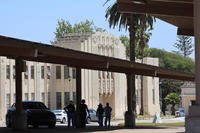 People are silhouetted against a historic building that has been marked for improvement at the West Los Angeles Veterans Affairs Medical Center campus, where President Trump's executive order is directing the Department of Veterans Affairs to set a goal of housing up to 6,000 homeless veterans at the center. (Allen J. Schaben/Los Angeles Times)