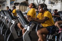 Sailors use exercise bikes during a physical readiness test in the hangar bay of the Nimitz-class aircraft carrier USS Harry S. Truman (CVN 75).