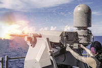 Navy Seaman Elizabeth Furlan fires a Mark 38 crew-served weapon system
