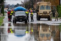 National Guard soldiers search a neighborhood flooded by the Skagit River.