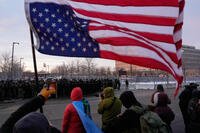 A person holds an upside-down American flag.