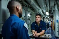 A sailor talks to a corpsman during sick call on a ship.