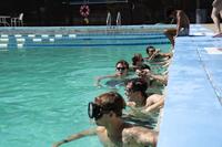 Recruits in swim masks line up in the water to start a timed test.