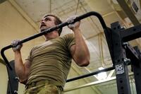 A soldier does a pullup.