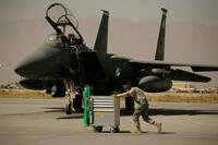 A U.S. Air Force airman pushes a cart past an F-15E Strike Eagle at Bagram Air Base in Afghanistan.