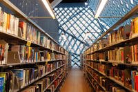 Rows of books line the walls of a modern library