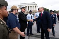 VA secretary shakes hands with veterans in front of the Lincoln Memorial.