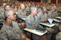 Marines in class at their desks listening to a lecture.