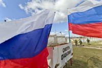 Russian flags decorate a vehicle as pro-Russian soldiers stand outside a Ukrainian military base in Perevalne, Ukraine, Monday, March 17, 2014. (AP Photo/Vadim Ghirda)