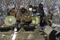 Ukrainian government soldiers sit on top of their armored vehicle driving on a road stretching away from the town of Artemivsk, Ukraine, towards Debaltseve, Tuesday, Feb. 17, 2015. (AP Photo/Petr David Josek)