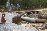 North Carolina National Guardsmen assigned to the 505th Engineer Battalion’s 882nd Engineer Company, assess the damage to a road in Eastover, S.C., Oct. 13, 2015. (North Carolina Army National Guard/Sgt. Brian Godette.)