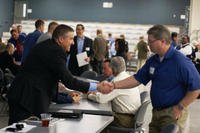 Steve Nolen, chief of planning and environmental division, shakes hands with a business representative during the Meet the Corps Day event.