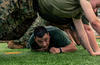 A Marine low crawls during PT.