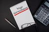 Wage Garnishment word concept written in a notebook with pen and calculator