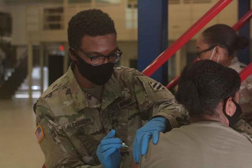 U.S. Army combat medic administers a flu vaccination.