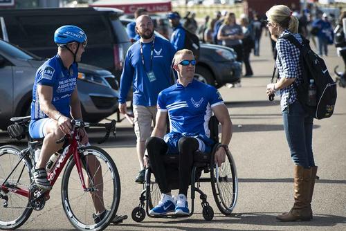Ashley Means stands by her husband Jeremiah as they talk to other Air Force wounded warriors at the Warrior Games cycling event, Sept. 9, 2014, at Fort Carson, Colo. Ashley is as a caretaker for Jeremiah, a former Senior Airman. (U.S. Air Force photo/Senior Airman Jette Carr) Air Force wounded warriors and a caregiver at the Warrior Games cycling event.