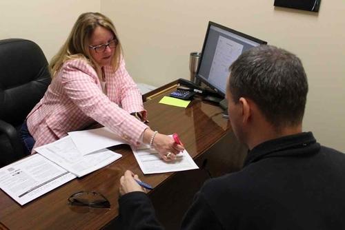 A volunteer tax preparer does a return for a U.S. Army soldier.