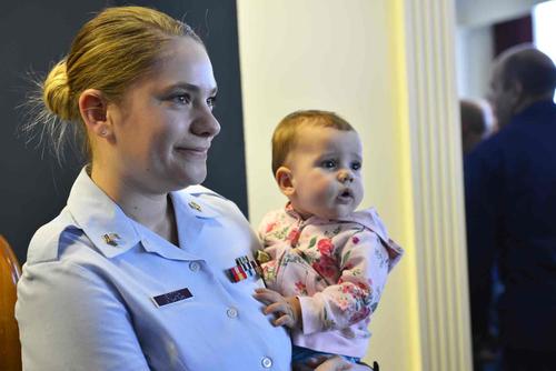 Coast Guard officer holds her daughter.