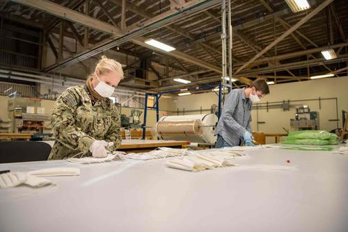 U.S. Navy sailor cuts reusable, cloth facemasks.