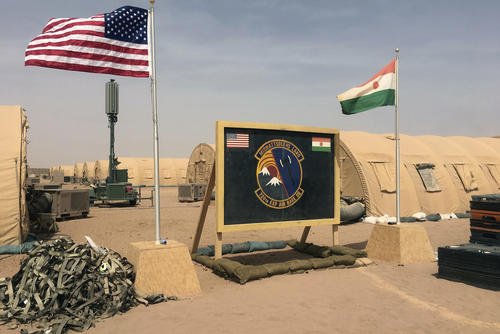 A U.S. and Niger flag are raised side by side at the base camp