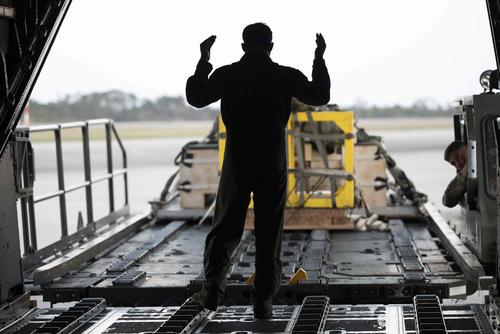 A loadmaster prepares to load an airdrop bundle on to an MC-130H