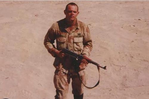 Army paratrooper Bill Glose, young, grim-faced and holding an AK-47 in Iraq -- the photo that would grace the cover of his first book of poetry, 'Half a Man.'