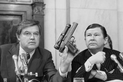 Chairman Frank Church, D- Idaho., the Senate Intelligence Committee, holds up a poison daft gun as co-chairman John G. Tower, R-Texas looks at the weapon during a session the panel's probe of the Central Intelligence Agency Tuesday, Sept. 17, 1975 in Washington.