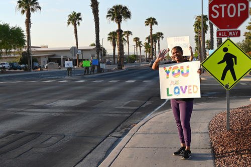 U.S. Air Force Chief Master Sgt. Adrienne Warren, the 99th Air Base Wing command chief, greets drivers during a Suicide Prevention Awareness Month base wave-in at Nellis Air Force Base, Nevada.