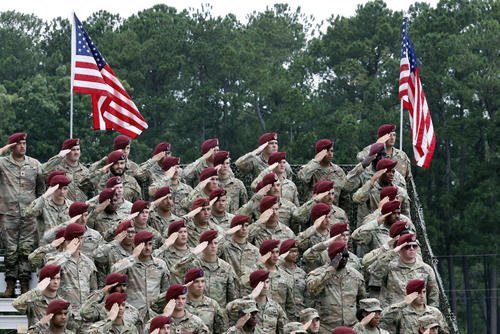 Soldiers of Fort Bragg salute during the playing of the national anthem