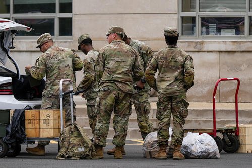 National Guard troops load supplies into a car trunk outside the District of Columbia National Guard Headquarters