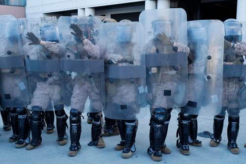 Marines stand guard as Angelenos rally against ICE raids.