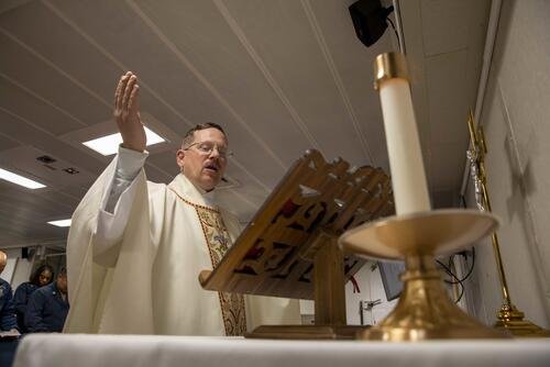 Navy Chaplain Cmdr. Jason M. Constantine leads a prayer during Easter vigil in the chapel of amphibious assault ship USS Makin Island (LHD 8), April 16, 2022. (U.S. Navy photo by Mass Communication Specialist 3rd Class Nadia Lund)