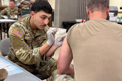 Munson Army Health Center Combat Medic Specialist Pfc. Antonio Lopez administers a seasonal influenza vaccine to a service member at a walk-in community flu-shot event at Frontier Chapel, Fort Leavenworth, Kansas, Nov. 19, 2025. (Maria Christina Yager/Munson Army Health Center Public Affairs)