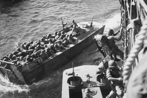 U.S. troops go over the side of a Coast Guard manned combat transport to enter the landing barges at Empress Augusta Bay, Bougainville, as the invasion gets under way." November 1943. (Photo: National Archives)